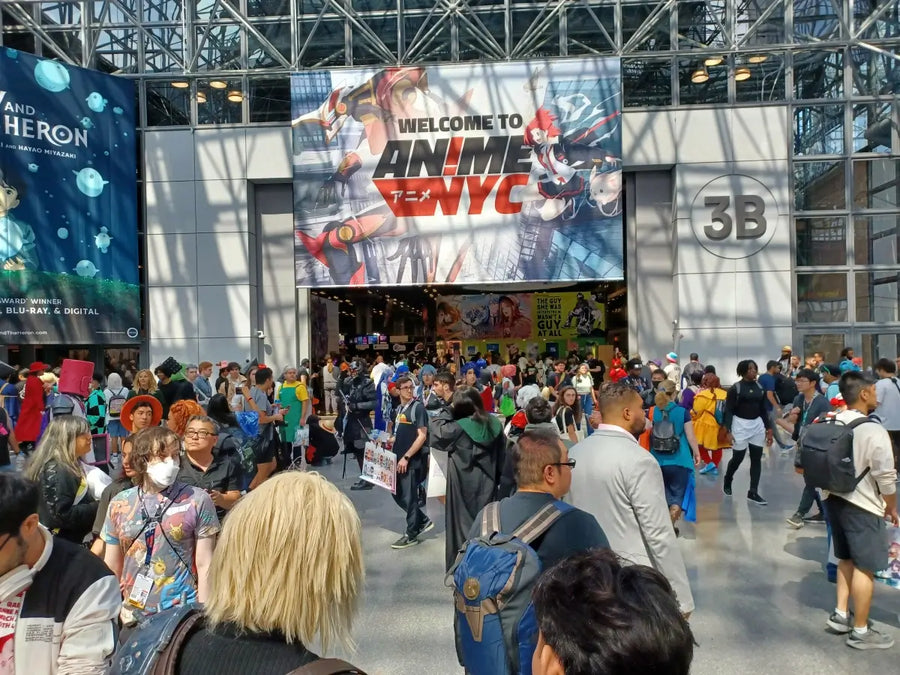 A busy anime convention hall filled with artist booths and visitors